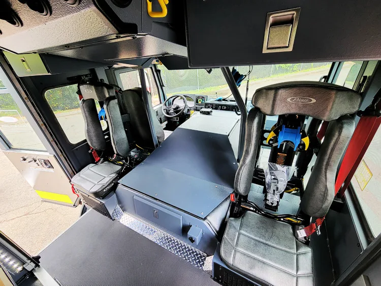 Cab interior side view showing front seats, center aisle, and dashboard area