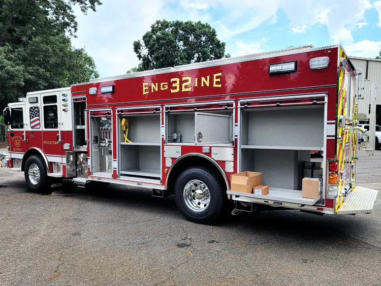 Rear-left profile showing pumper body with open side compartments