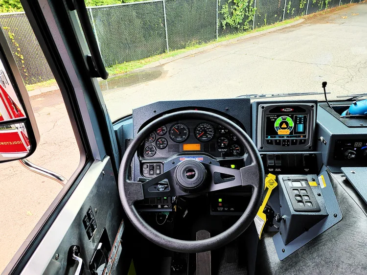 Driver cockpit view showing steering wheel, dashboard controls, and center console