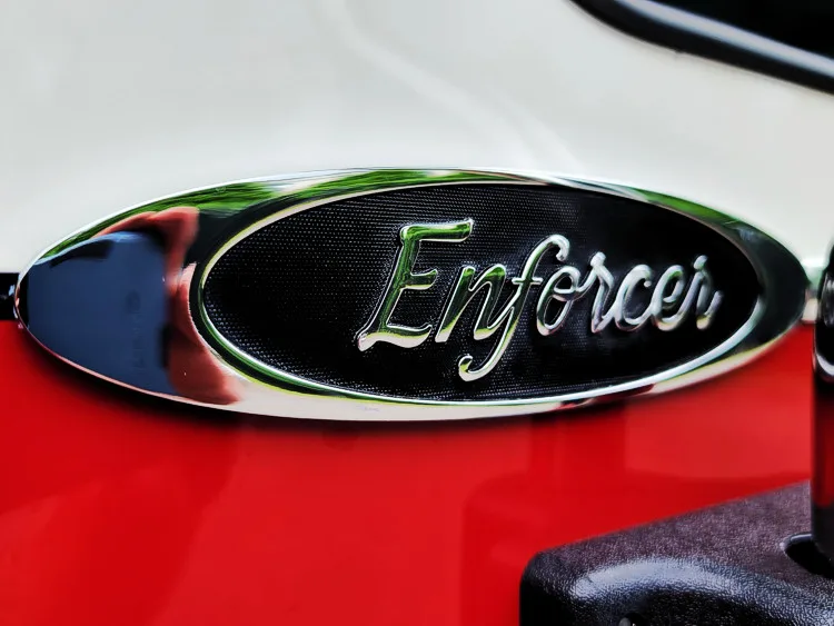 Body badge close-up showing Enforcer emblem on red panel