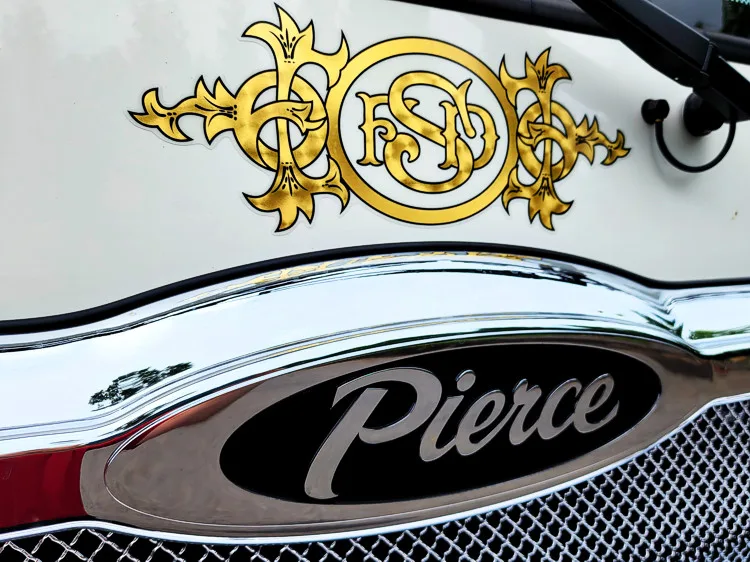 Front grille close-up showing Pierce badge and decorative gold lettering