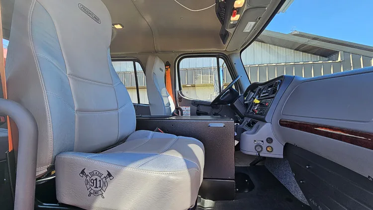 Cab interior side view showing front seat and dash controls