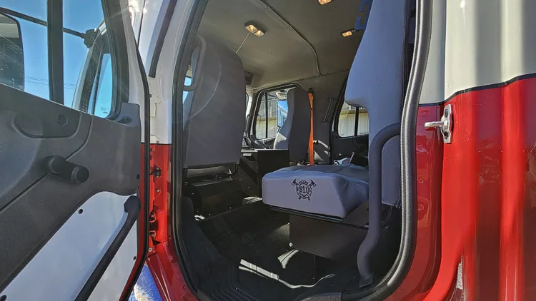 Rear cab interior view showing bench seat and open rear door