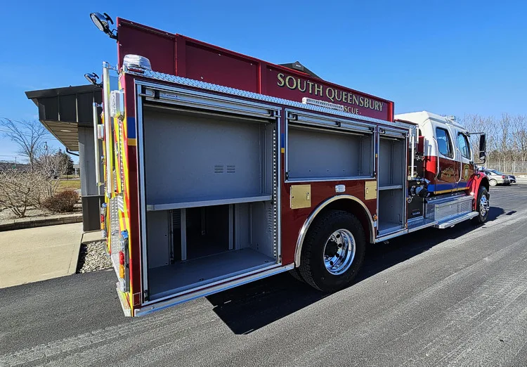 Rear-right profile showing open side body compartments and wheel area