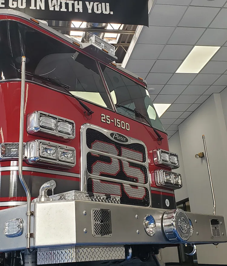 Front-left close-up indoors showing grille, bumper, and cab corner
