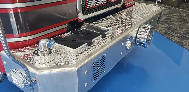 Front bumper close-up showing intake ports, lights, and treadplate step