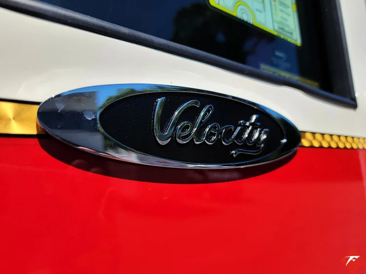 Window badge close-up showing Velocity emblem on dark glass panel
