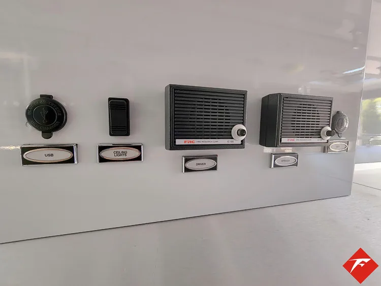 Interior wall close-up showing labeled control buttons and intercom panel