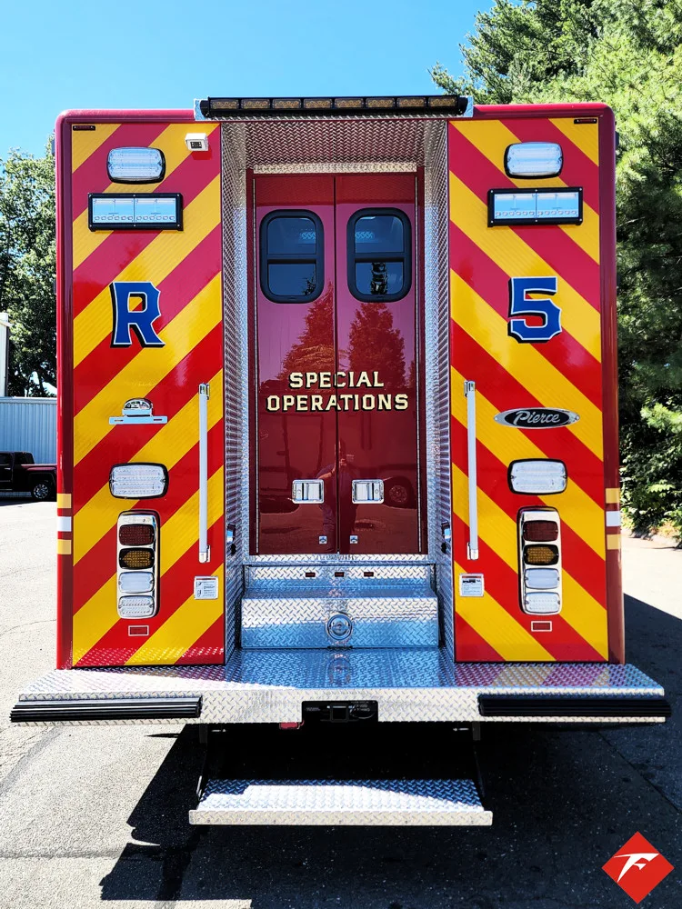 Rear view showing red-and-yellow chevrons and closed rear doors