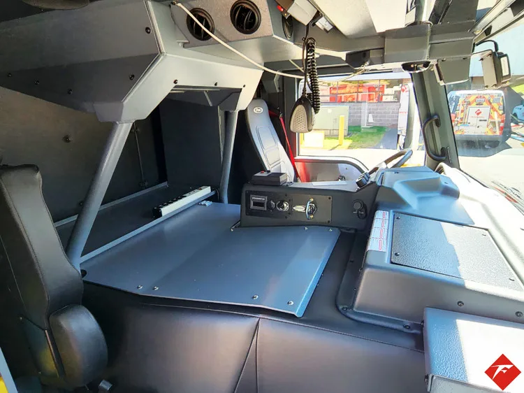 Cab interior view showing front seats, dashboard, and center workspace
