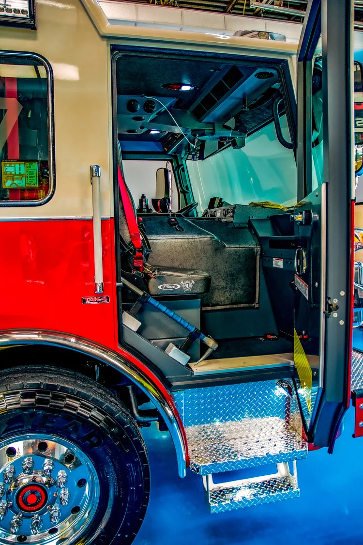 Cab doorway interior view showing front seat, dashboard controls, and step entry