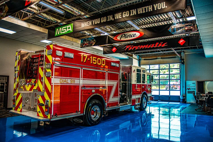 Rear-right view indoors showing chevrons, hosebed area, and side body compartments
