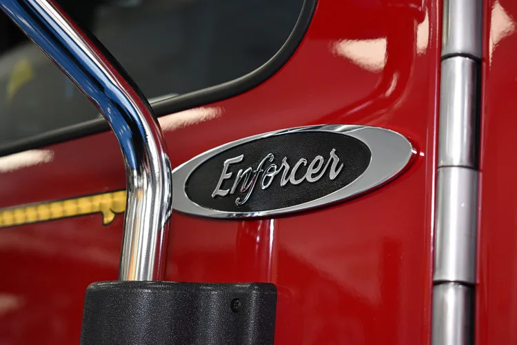 Body badge close-up showing Enforcer emblem on red panel