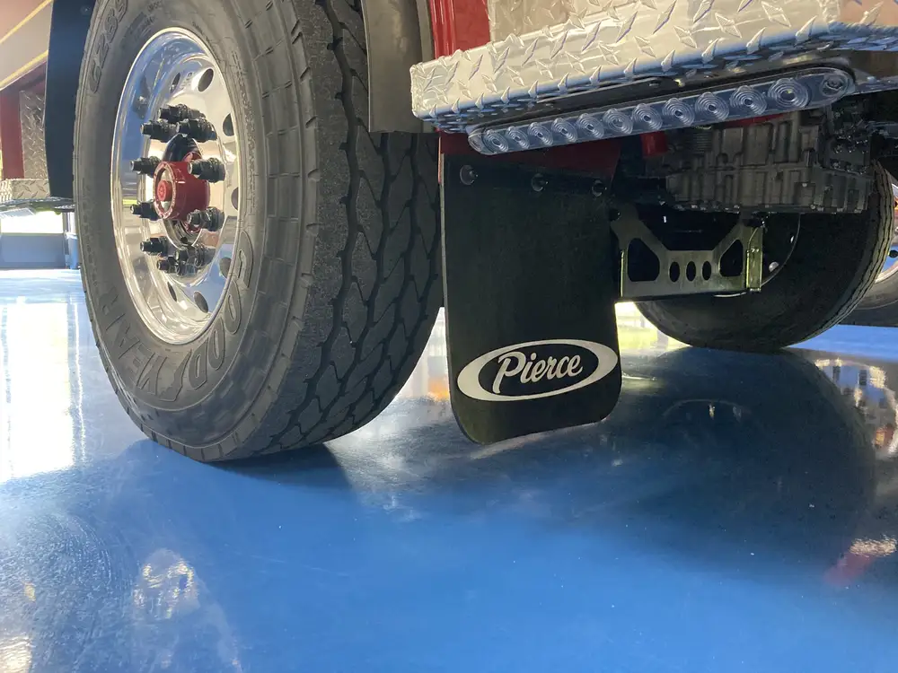 Rear wheel area close-up showing tire, mud flap, and lower trim