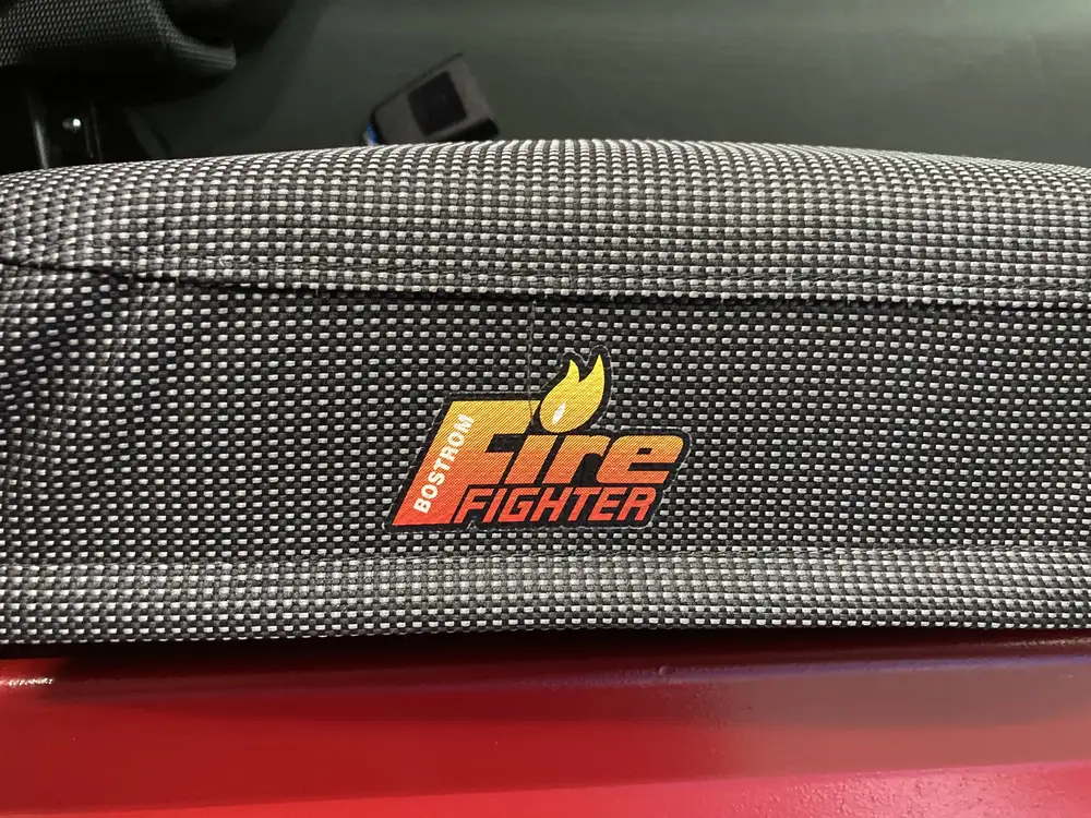 Seatback close-up showing Fire Fighter text on dark fabric