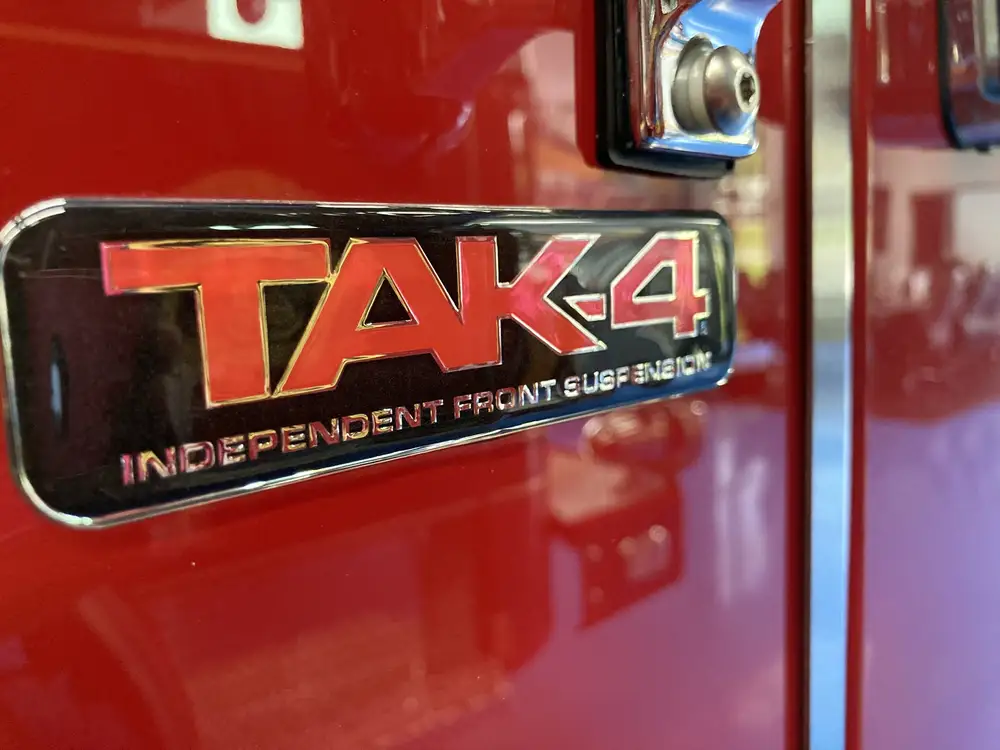 Body badge close-up showing TAK-4 suspension emblem
