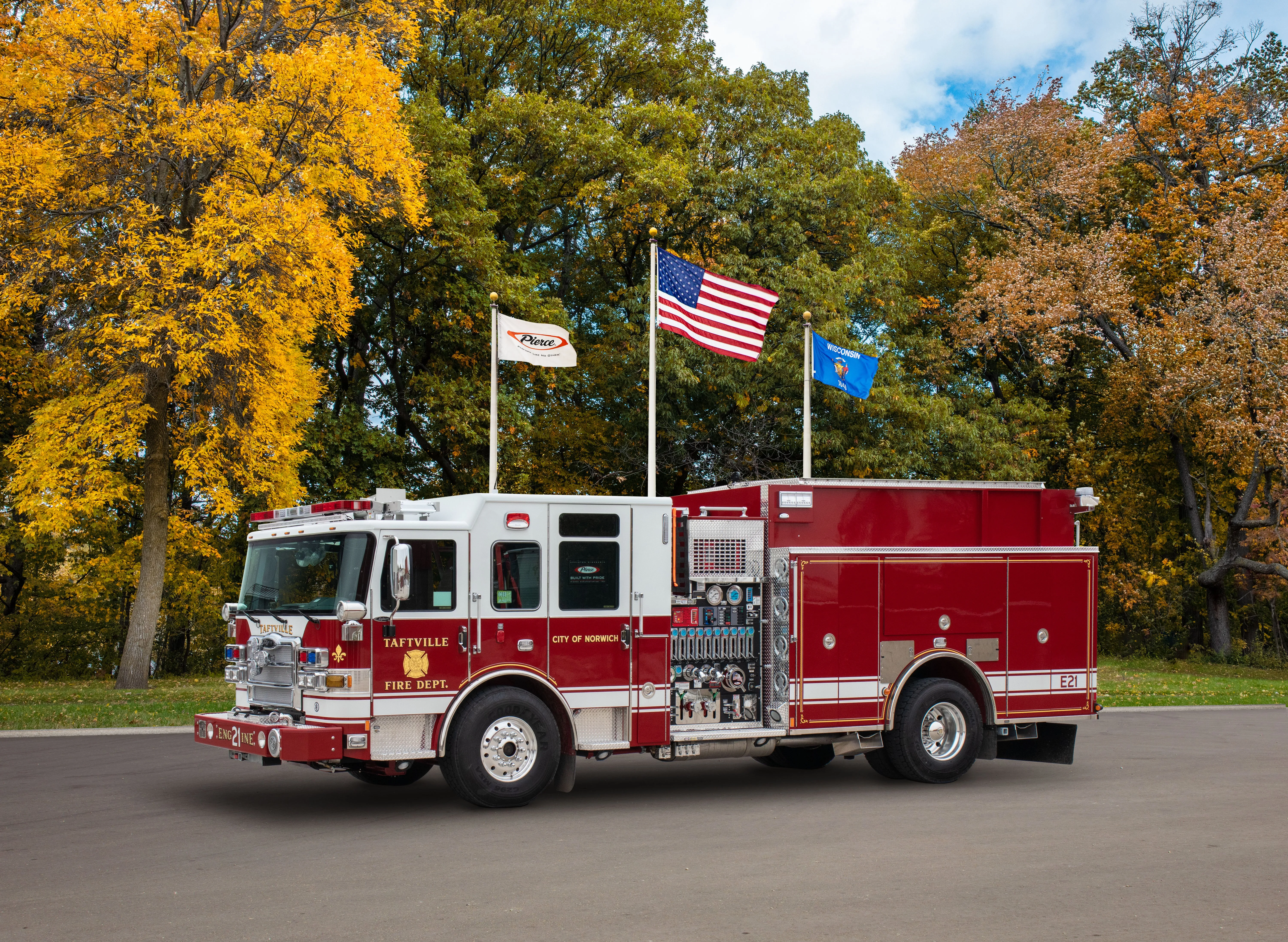 Taftville fire engine driver-side profile in autumn setting with exposed pump panel and compartment doors