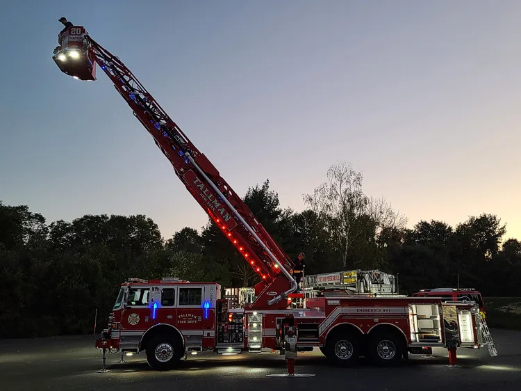 Evening exterior view showing tower ladder from rear with aerial extended