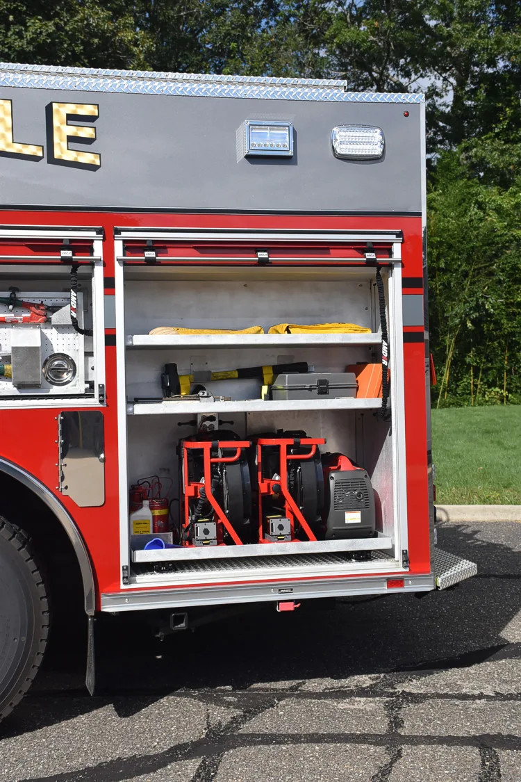 Open side compartment showing tools and equipment near rear wheel