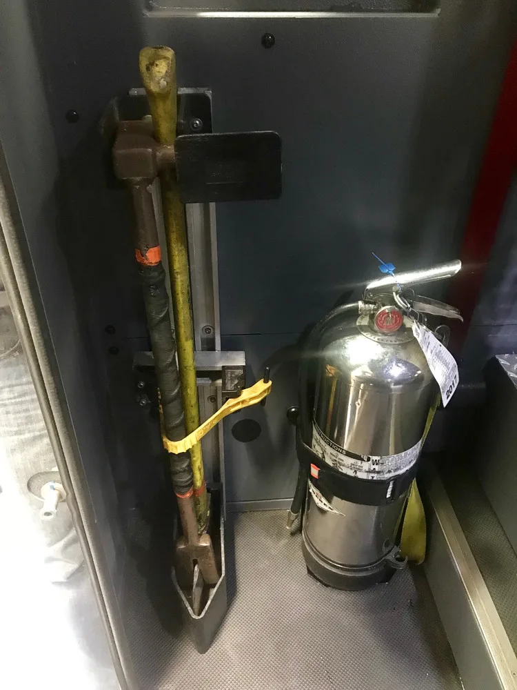 Open narrow compartment showing mounted extinguisher and side fittings