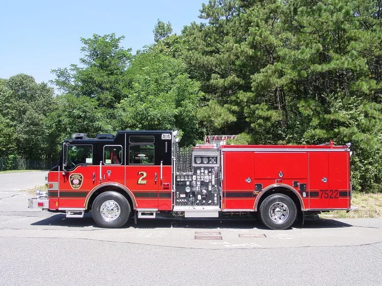 Driver-side full profile showing exposed pump panel controls, side compartments, and wheelbase.