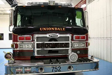 Head-on front view showing windshield, chrome grille, warning lights, and bumper intakes.