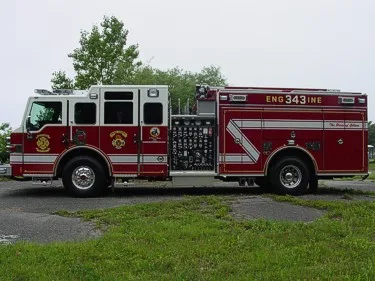 Driver-side profile showing exposed pump panel and side compartments