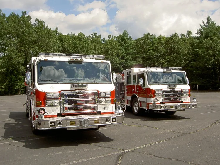 Front view of two pumpers showing grilles, bumpers, and warning lights
