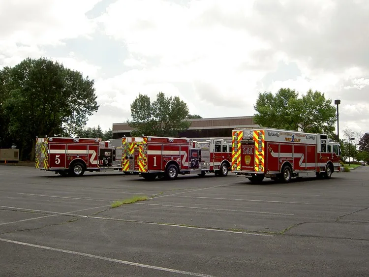 Wide rear-side lineup view showing multiple apparatus in parking lot