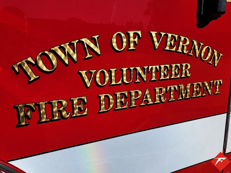 Body side lettering close-up on red panel with gold lettering