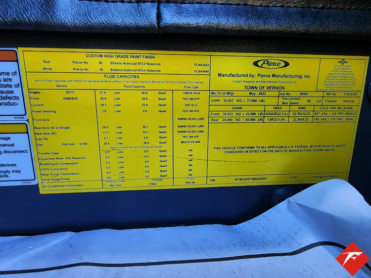 Cab door-jamb close-up showing yellow specification label plate