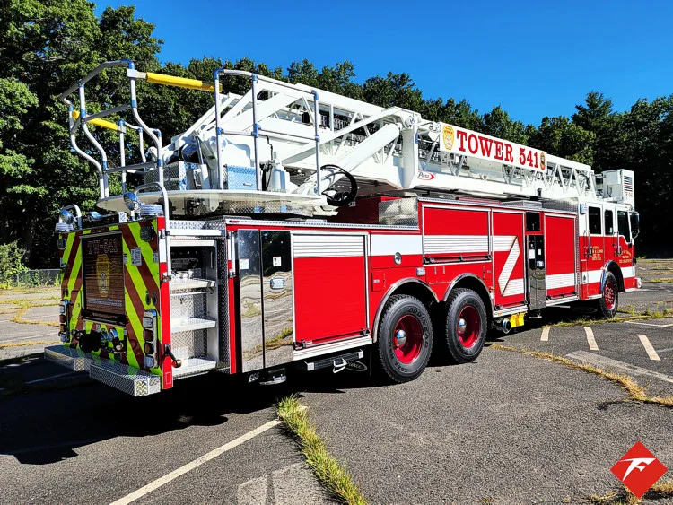 Rear-left exterior view showing ladder bed, side body, and tandem rear wheels