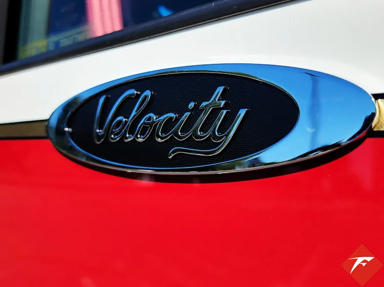 Body badge close-up showing Velocity emblem on red panel