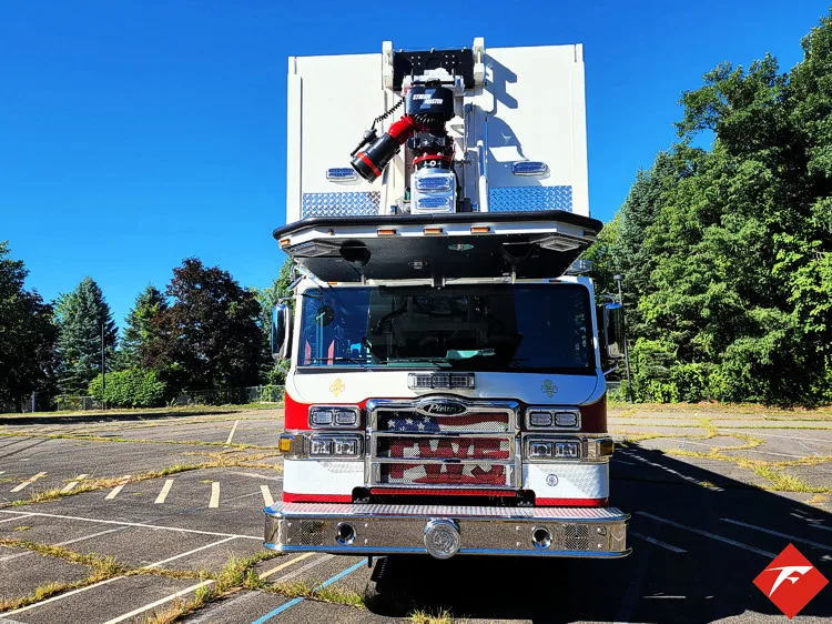 Head-on front view showing grille, bumper, and bucket above cab