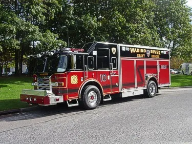 Front-left wide view showing the heavy rescue body, side roll-up doors, and wheelbase.
