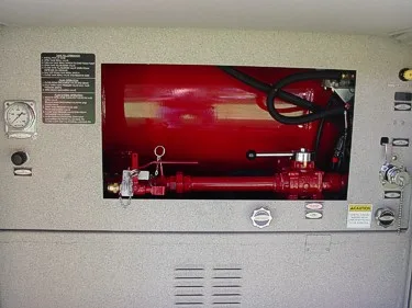 Open side-compartment close-up showing mounted red tank, plumbing components, and control fittings.