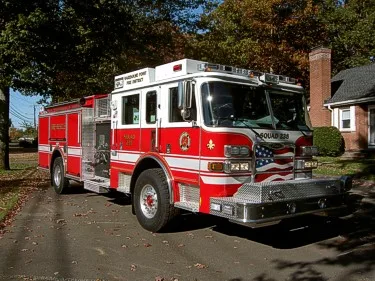 Front-right exterior view showing the cab, bumper, pump panel, and side compartments.