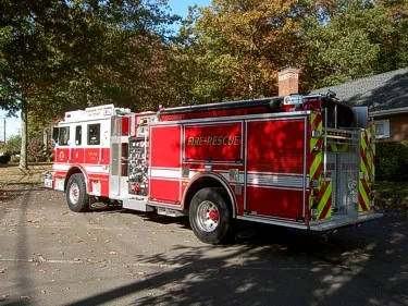 Rear-right exterior view with rear chevrons, side compartment doors, and rear wheel area.