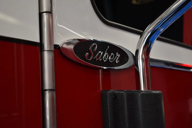 Body badge close-up showing Saber emblem on red panel