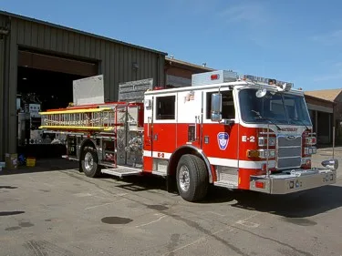 Tiller aerial truck side profile showing tractor cab, trailer body, and ladder assembly