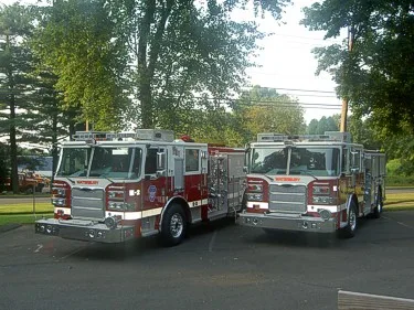 Front view of two pumpers parked side by side showing grilles and bumpers