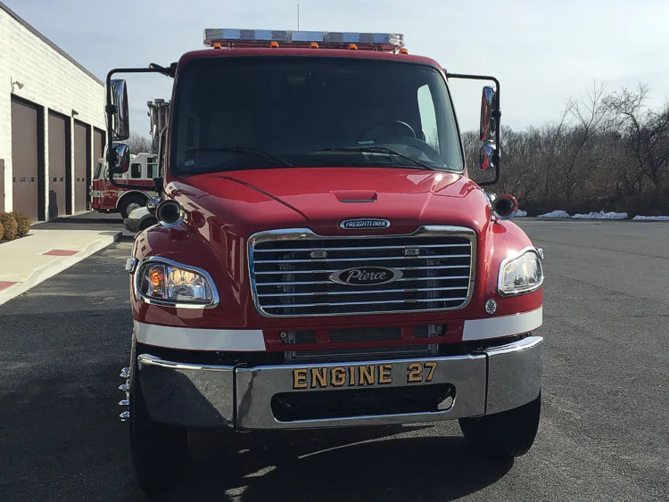 Front-left close-up indoors showing grille, bumper, and cab corner