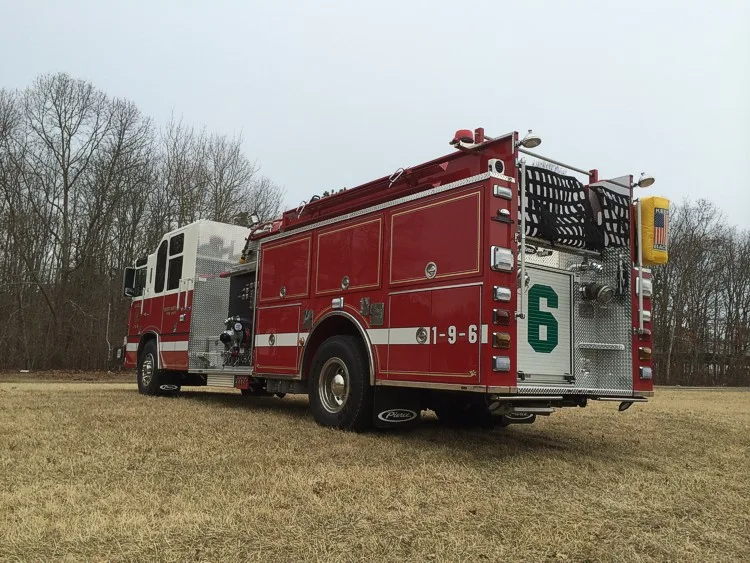 Rear-right exterior view showing side compartments, rear body panel, and rear wheel area.