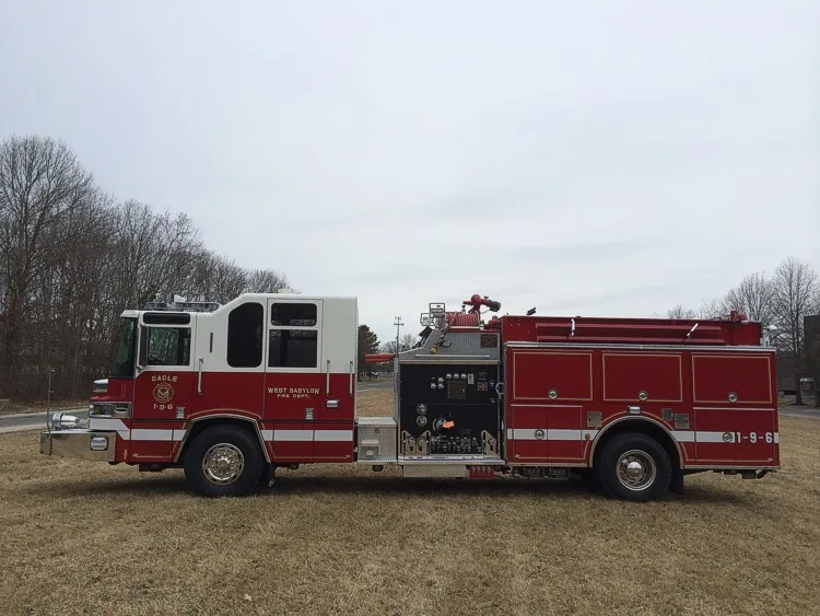 Officer-side profile view showing exposed pump panel controls and side compartment doors.