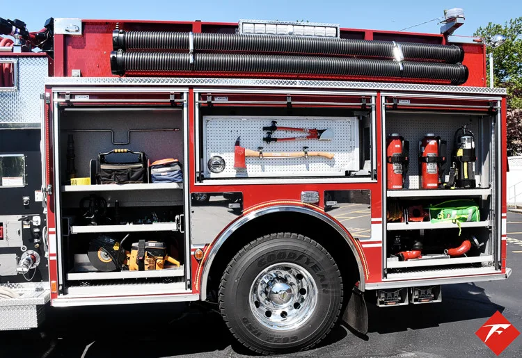 Open side compartment showing hand tools, extinguishers, and storage shelves