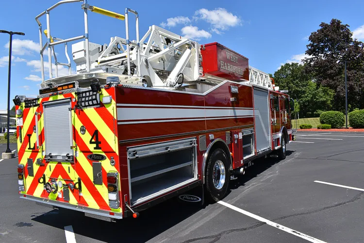 Rear-left exterior view showing chevrons, side body, and tandem wheels