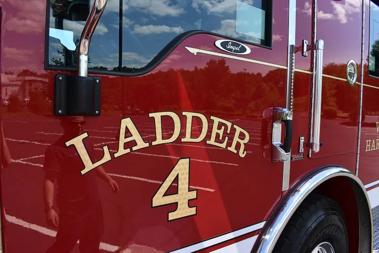 Cab door close-up showing raised ladder-unit lettering on red paint