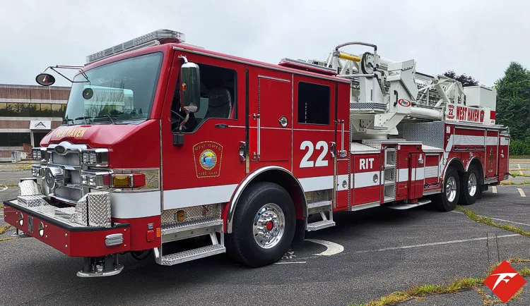 Front-left exterior view showing cab, grille, and ladder bed