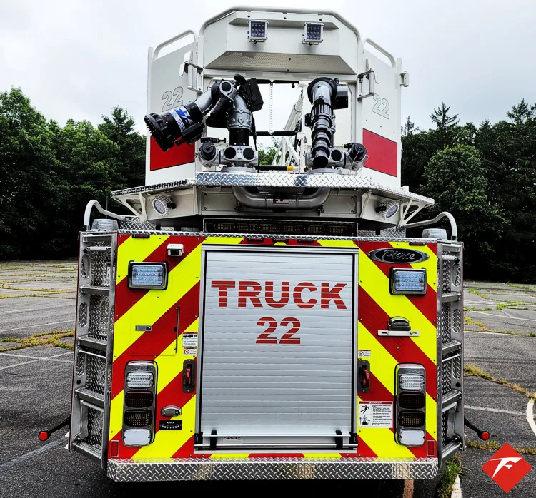 Rear view showing red-and-yellow chevrons and bucket at ladder tip