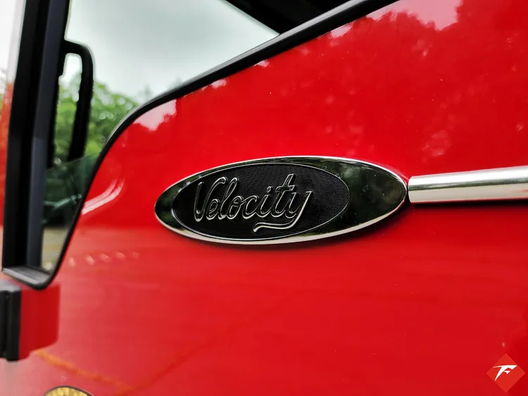 Body badge close-up showing Velocity emblem on red panel